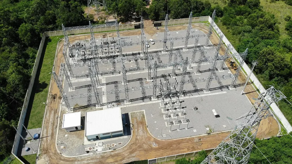 Vista aérea de subestação de energia elétrica cercada por mata