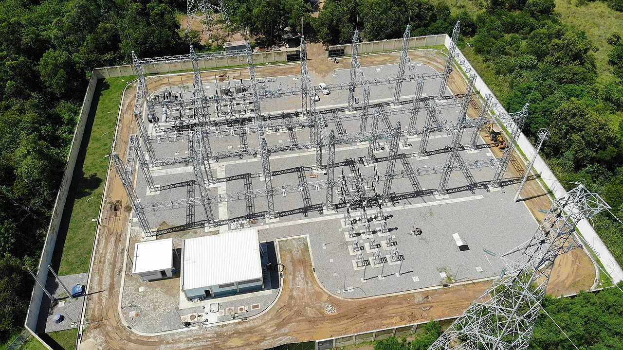 Vista aérea de subestação de energia elétrica cercada por mata